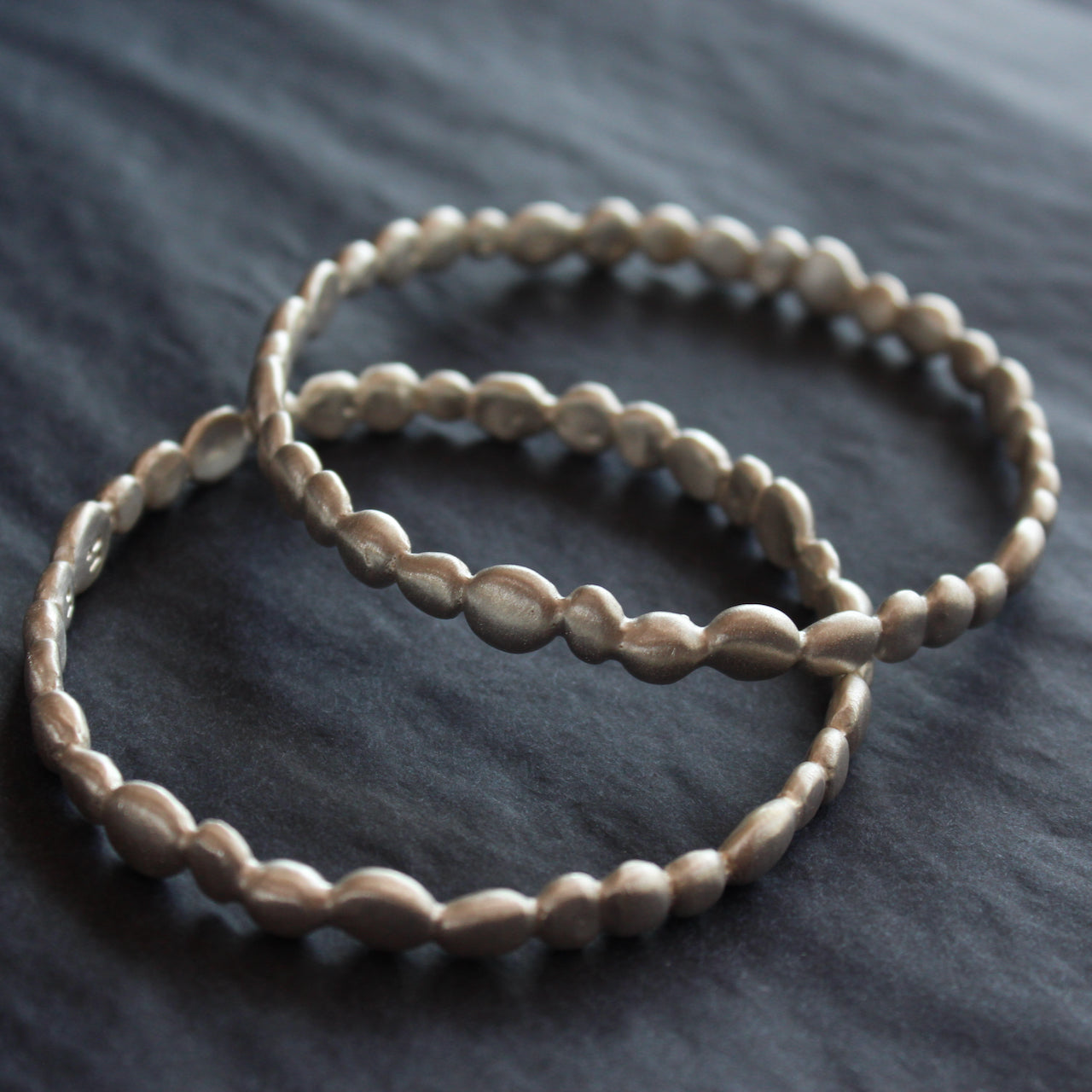 a pair of silver bangles made up of small silver pebbles by Cornwall jeweller Carin Lindberg