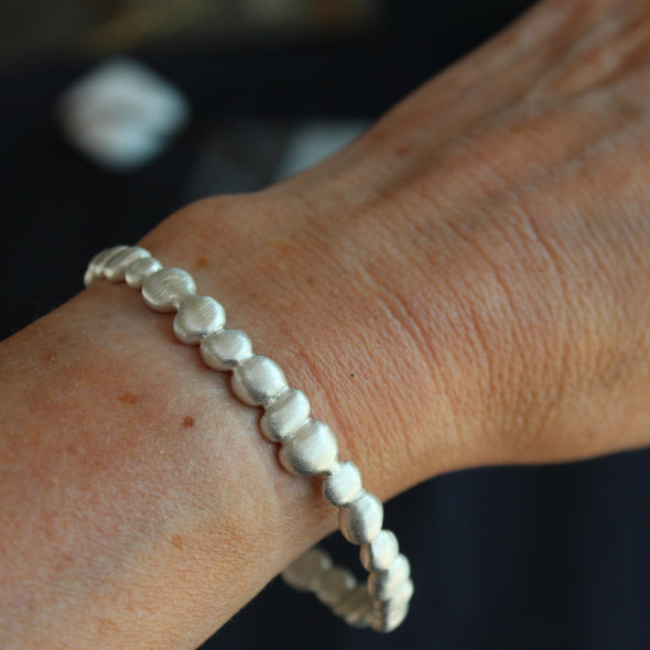 a silver bangle made up of small silver pebbles by Cornwall jeweller Carin Lindberg.