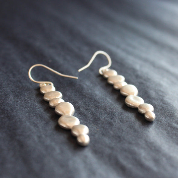 silver drop earrings of joined together small silver pebbles by jewellery designer Carin Lindberg