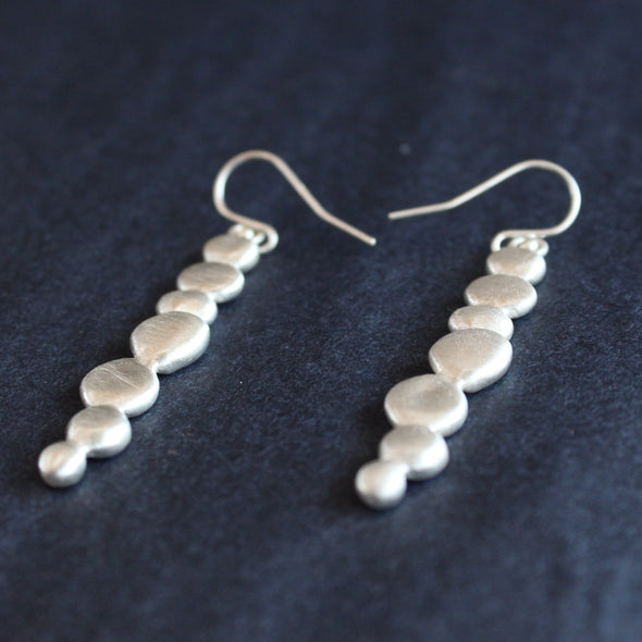 a pair of silver drop earrings of joined together small silver pebbles by UK jewellery designer Carin Lindberg
