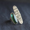 a large ring by Cornwall jeweller Carin Lindberg with an oval shaped green stone and a larger silver lozenged shape.