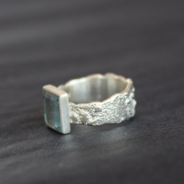 a silver ring by Cornwall Jeweller Carin Lindberg with a square set pale blue aquamarine stone and textured silver band