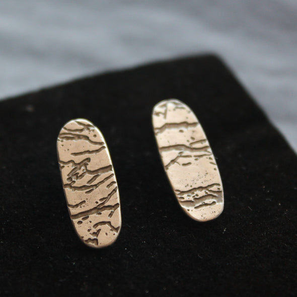 a pair of long oval silver stud earrings with etched detail by Cornwall jewellery designer Carin Lindberg.