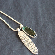 a double pendant on silver chain of blue green stone and oval shaped silver disc by Cornwall jewellery designer Carin Lindberg 