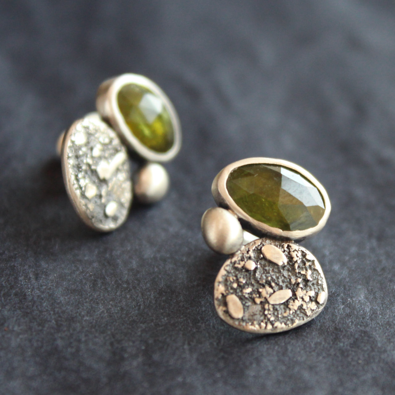 a pair of silver stud earrings with a green stone set in silver by Carin Lindberg jewellery designer
