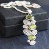 silver pendant of green stones and silver discs hanging from a silver chain by UK jewellery designer Carin Lindberg