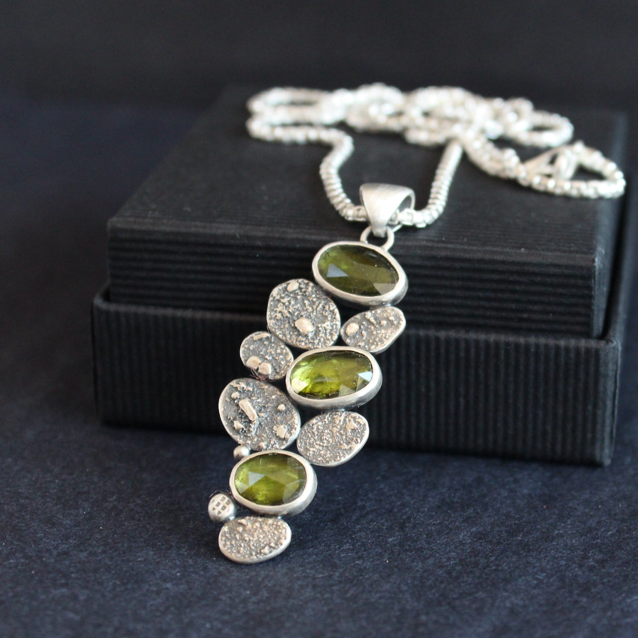 silver pendant of green stones and silver discs hanging from a silver chain by Cornwall jewellery designer Carin Lindberg