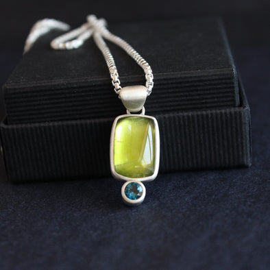 silver pendant with a bright green stone set in silver oval and small blue stone below by Cornwall jewellery designer Carin Lindberg