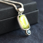 silver pendant with a bright green stone set in silver oval and small blue stone below by Cornwall jeweller Carin Lindberg