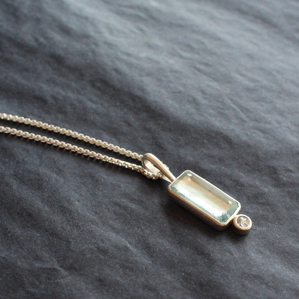 silver pendant with pale blue rectangular stone and round white diamond by Cornwall jeweller Carin Lindberg