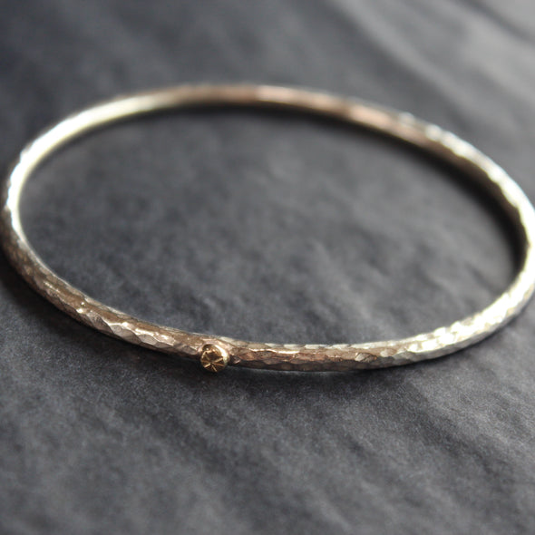 narrow textured silver bangle with small gold dot by Cornwall jewellery designer Lucy Spink 