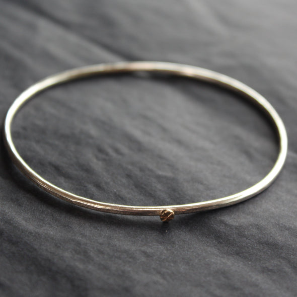 a fine sliver bangle with small gold star by Cornwall jewellery designer Lucy Spink.
