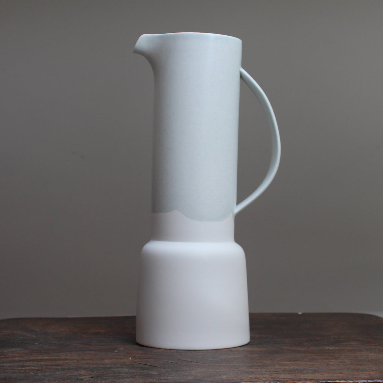 Pale Green and white ceramic jug by ceramicist Laura Plant on a wooden table