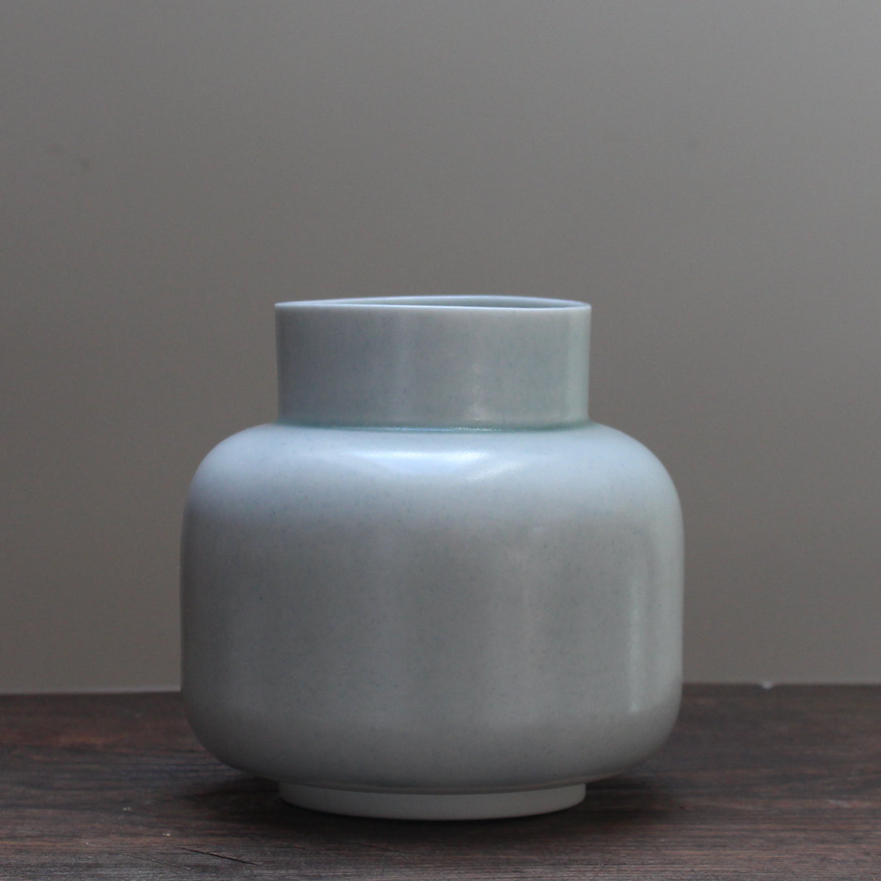 Pale Green ceramic vase by ceramicist Laura Plant on a wooden table