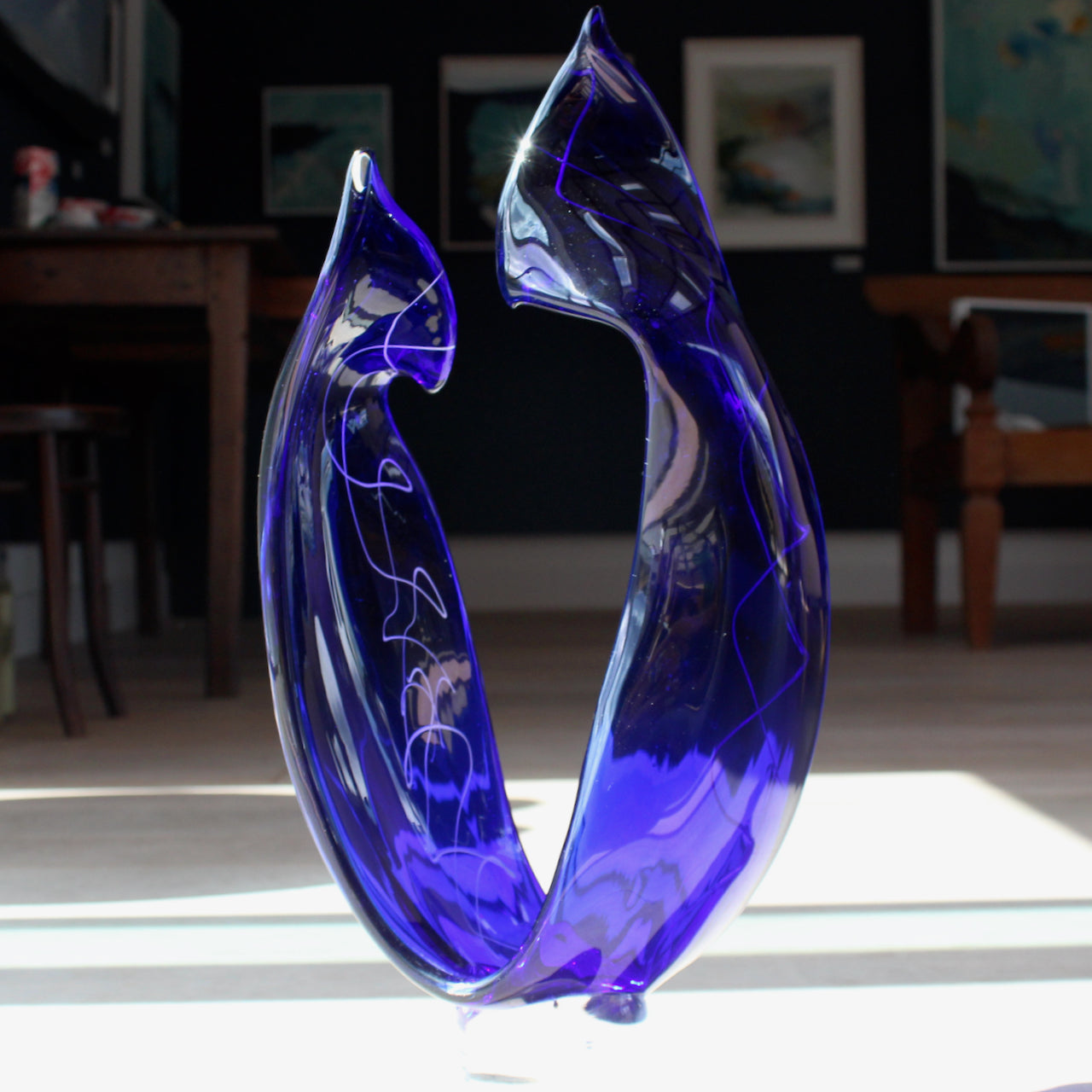 tall blue glass sculpture with white detail by glass artist Benjamin Lintell 