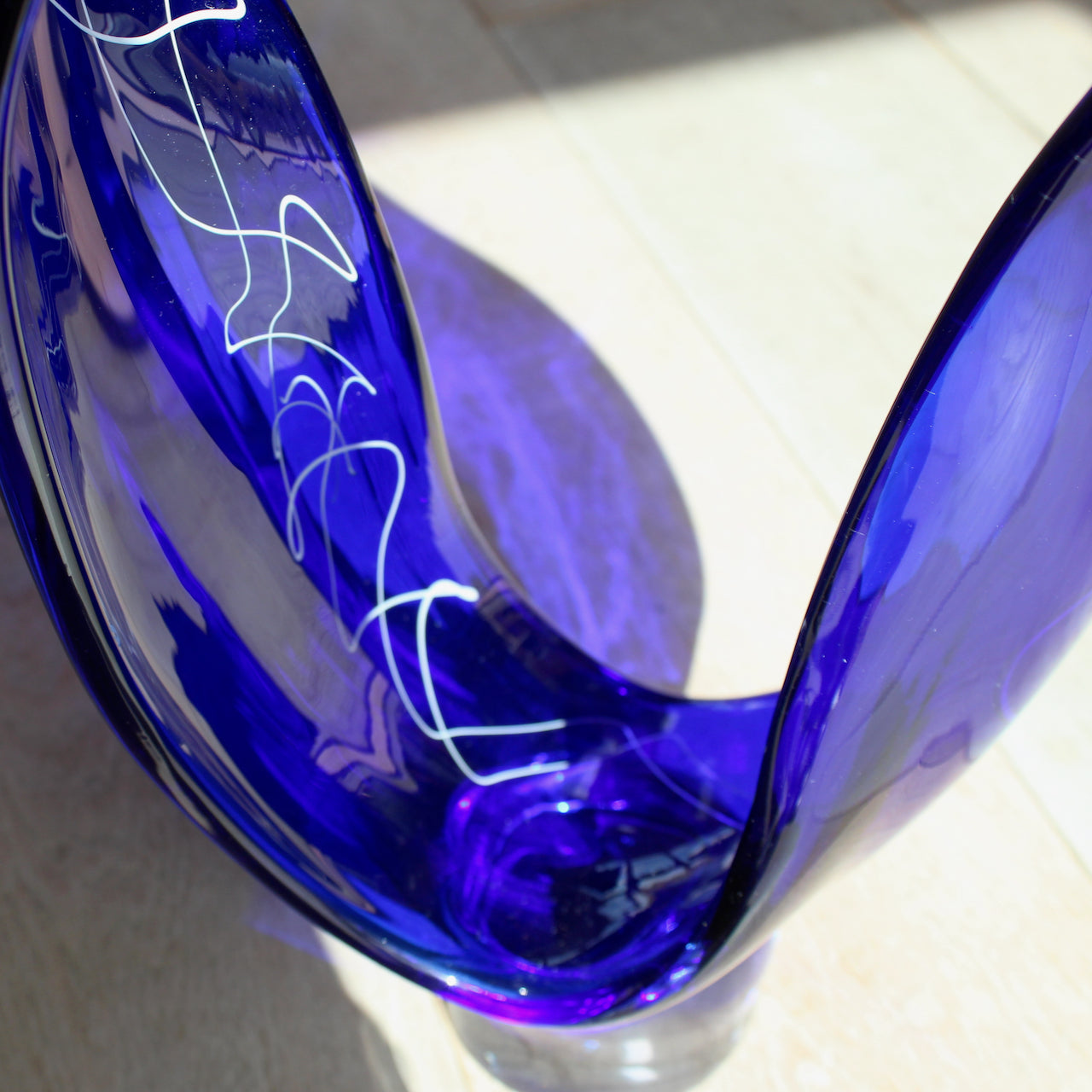 close up detail of a tall blue glass sculpture with white detail by glass artist Benjamin Lintell