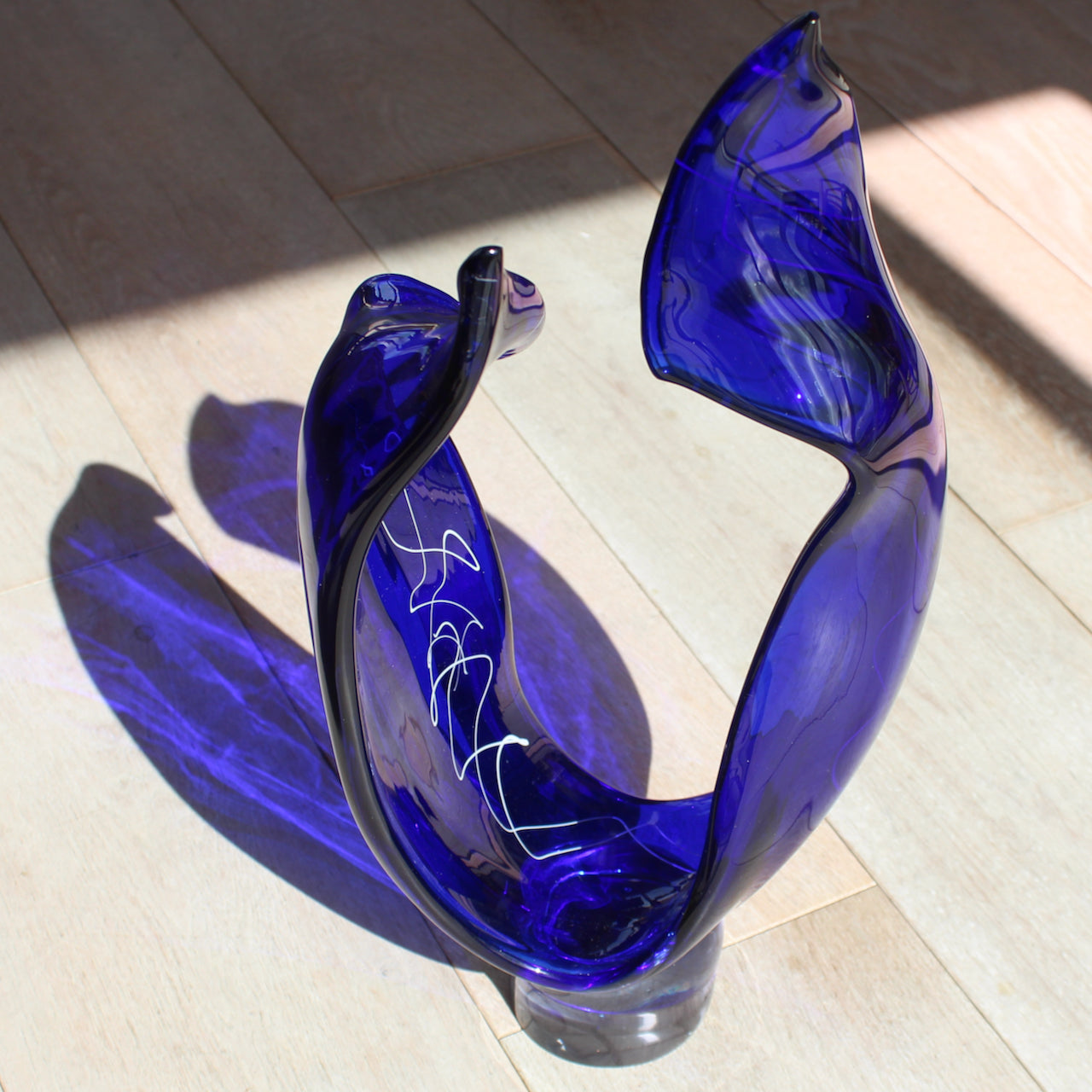 a tall blue glass sculpture with white detail by UK glass artist Benjamin Lintell 