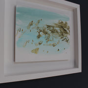 pale blue, white and brown abstract Katy Brown painting in a white frame of flotsam on a sandy beach