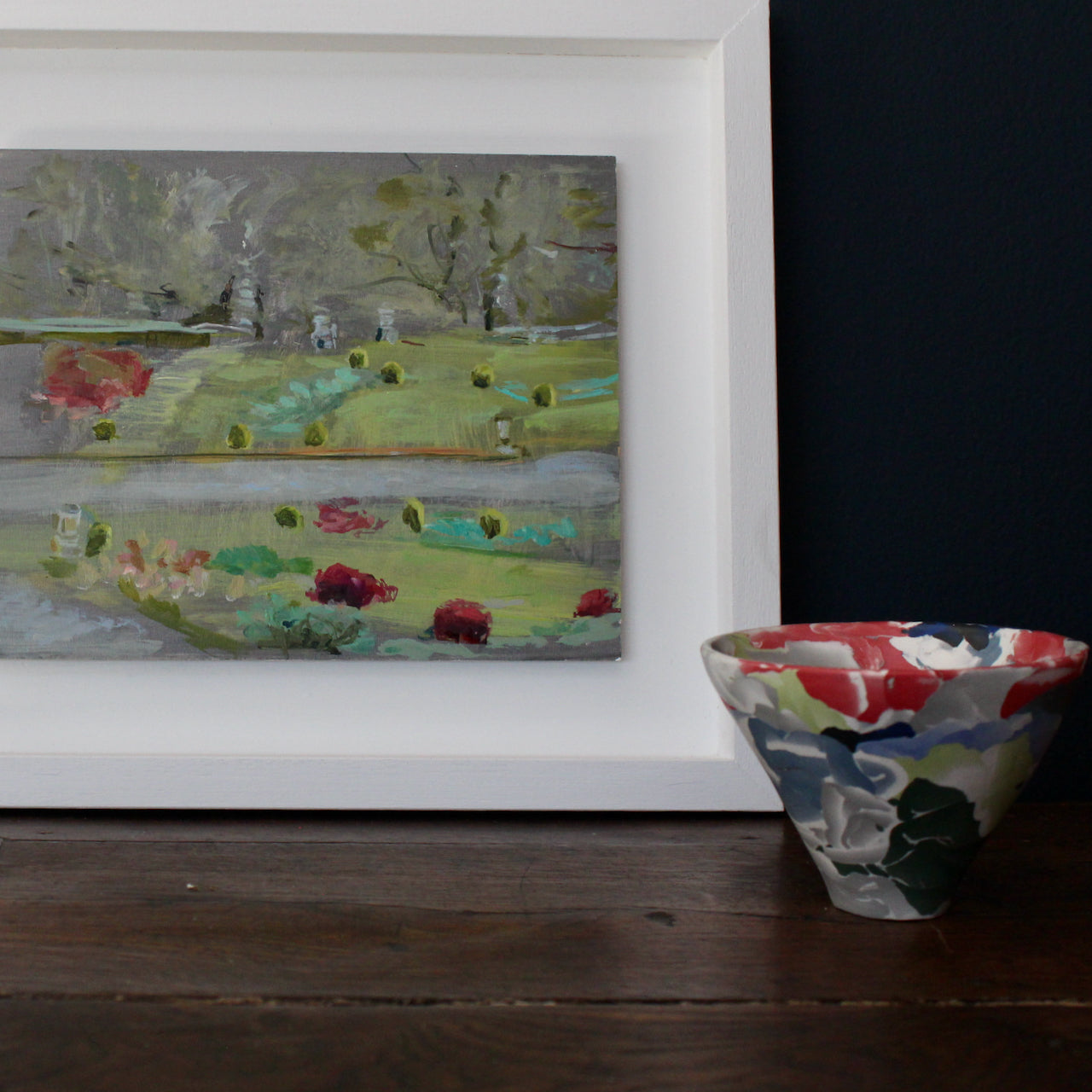 oil painting by Cornish based artist Katy Brown with trees in the distance, bushes, and red flowers