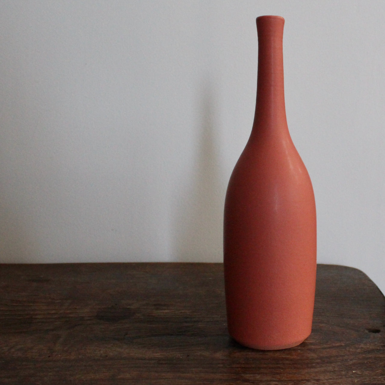 a deep coral  coloured ceramic bottle by UK ceramic artist Lucy Burley