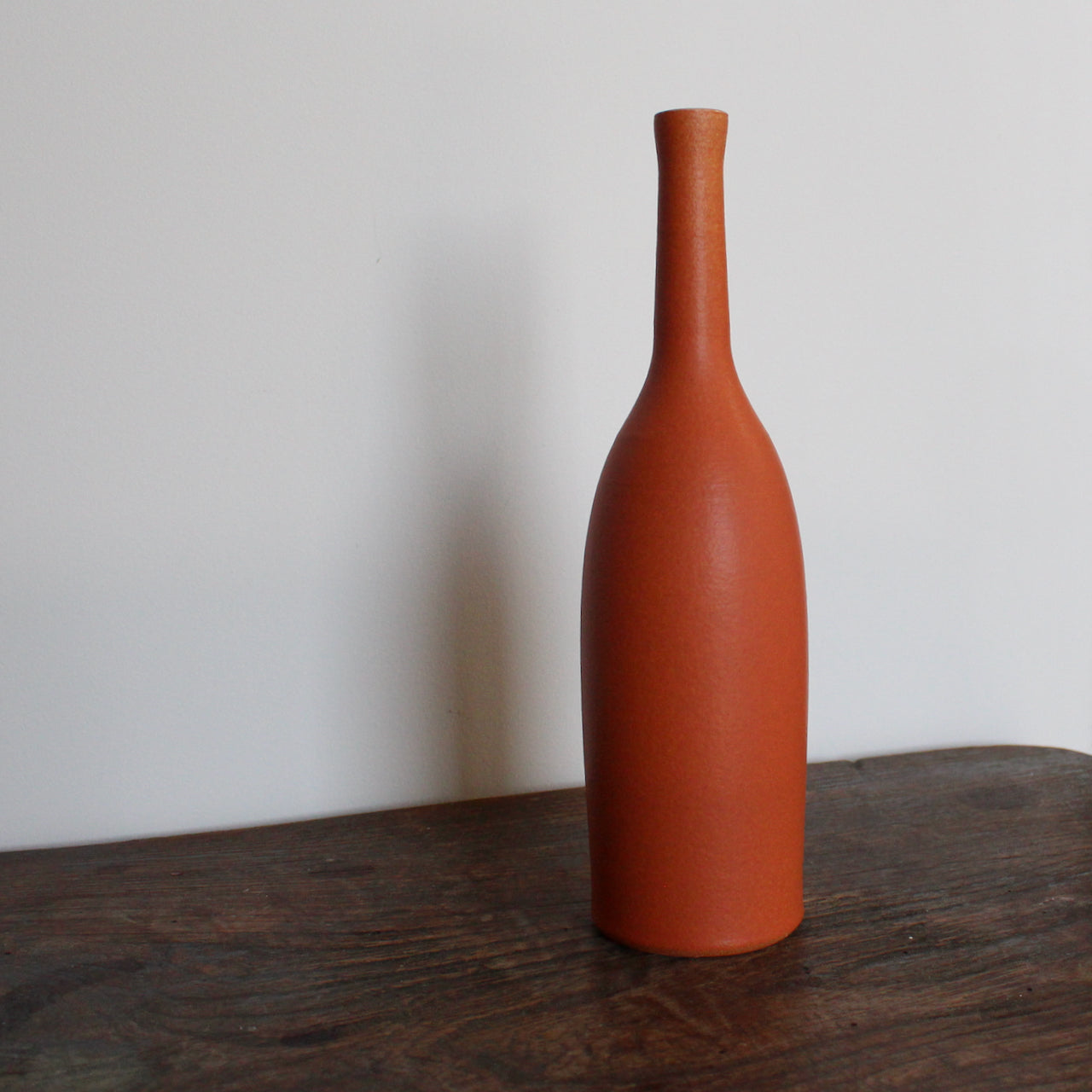 an orange coloured ceramic bottle by UK ceramic artist Lucy Burley
