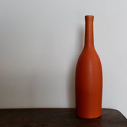 an orange coloured ceramic bottle by UK ceramicist Lucy Burley. 