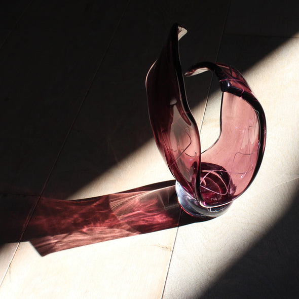 Benjamin Lintell glass sculpture in amethyst coloured glass photographed in the sunlight