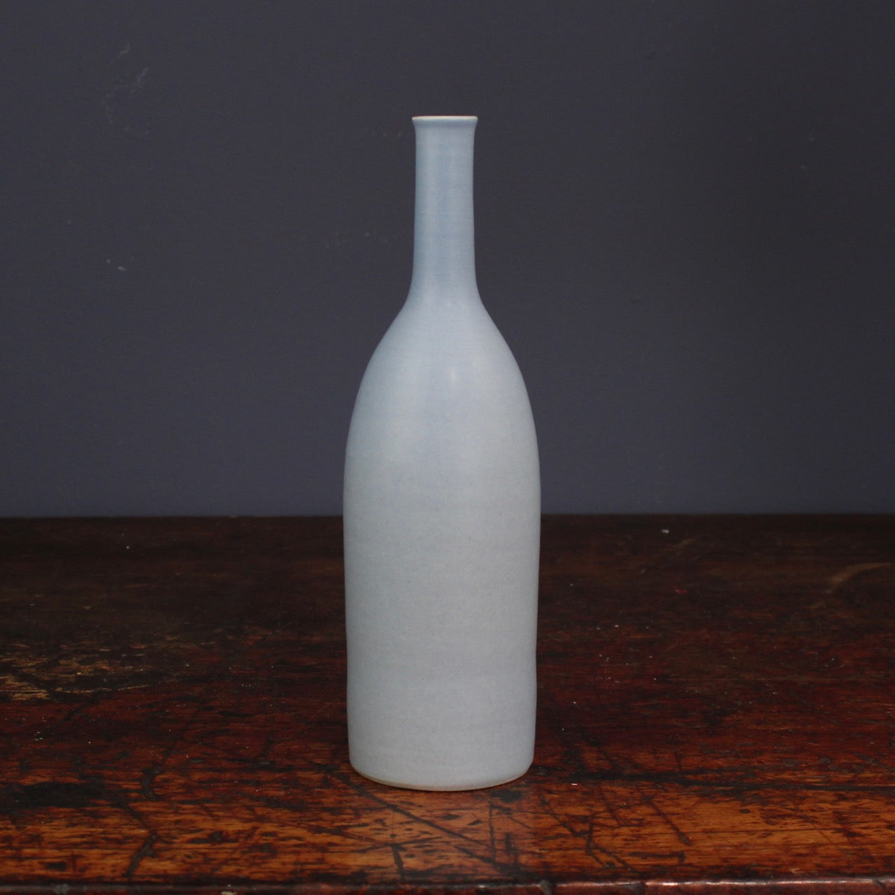 pale blue bottle by Lucy Burley on a wooden table
