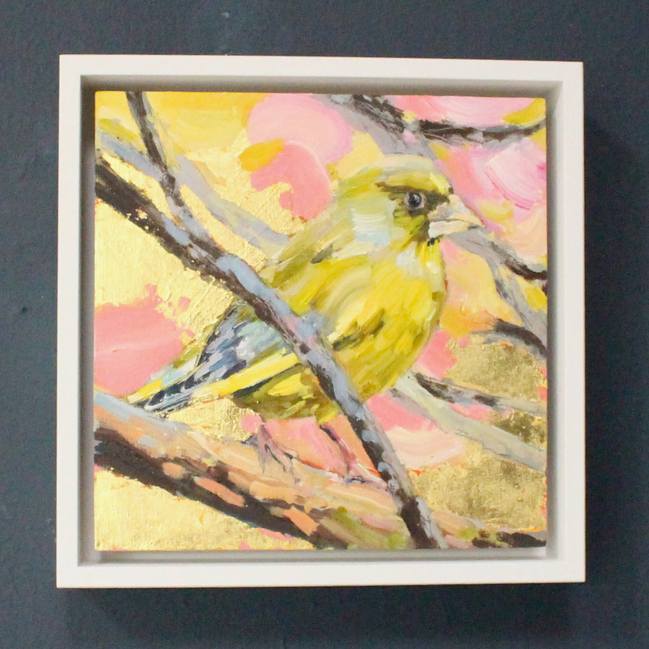Jill Hudson painting of a greenfinch on a branch with a pink, yellow and gold background
