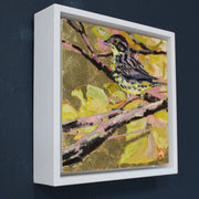 framed Jill Hudson painting of a yellow hammer bird on a branch amid leaves in shades of yellow, gold and pink.
