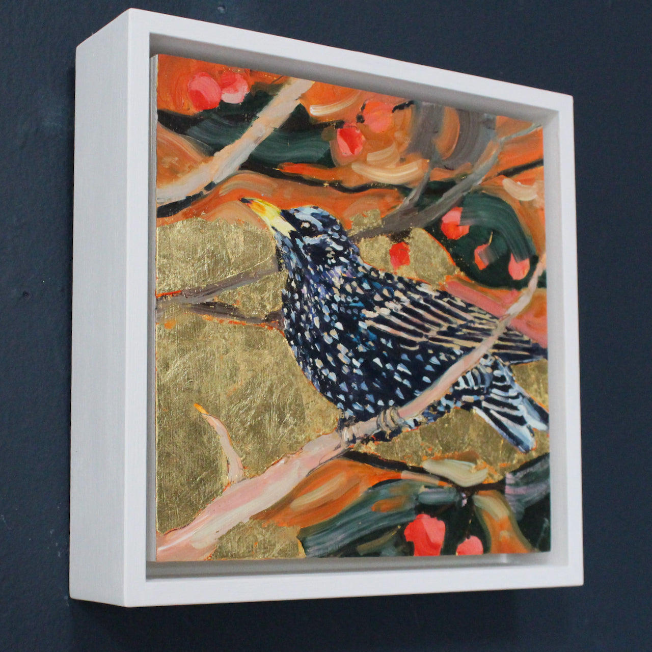 a Jill Hudson painting of a starling on a branch with and orange and gold background.