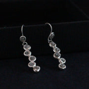a pair of Carin Lindberg  silver drop earrings with small diamonds encased in silver settings.