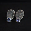 a pair of pair of Carin Lindberg textured silver earrings teardrop shape with silver encased small purple stone.