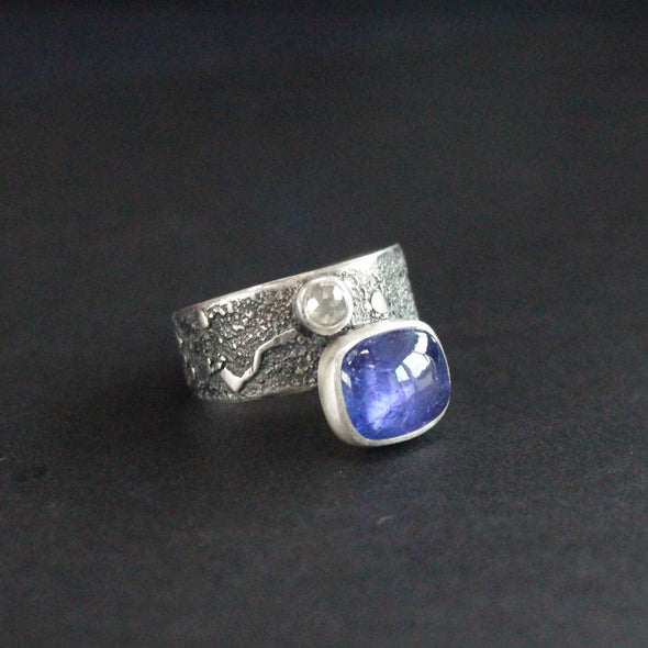 Carin Lindberg textured silver ring with a large oval blue stone and a smaller white diamond 