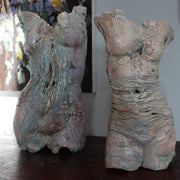 two textured ceramic torsos made by Pauline Lee standing on a wooden table 