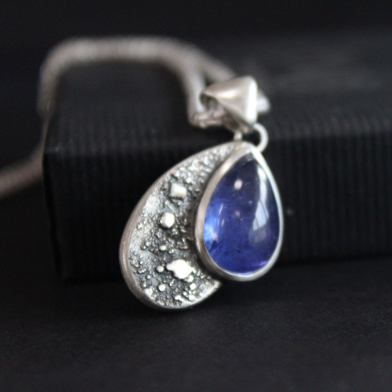 Carin Lindberg pendant of a teardrop textured silver and blue stone on a silver chain