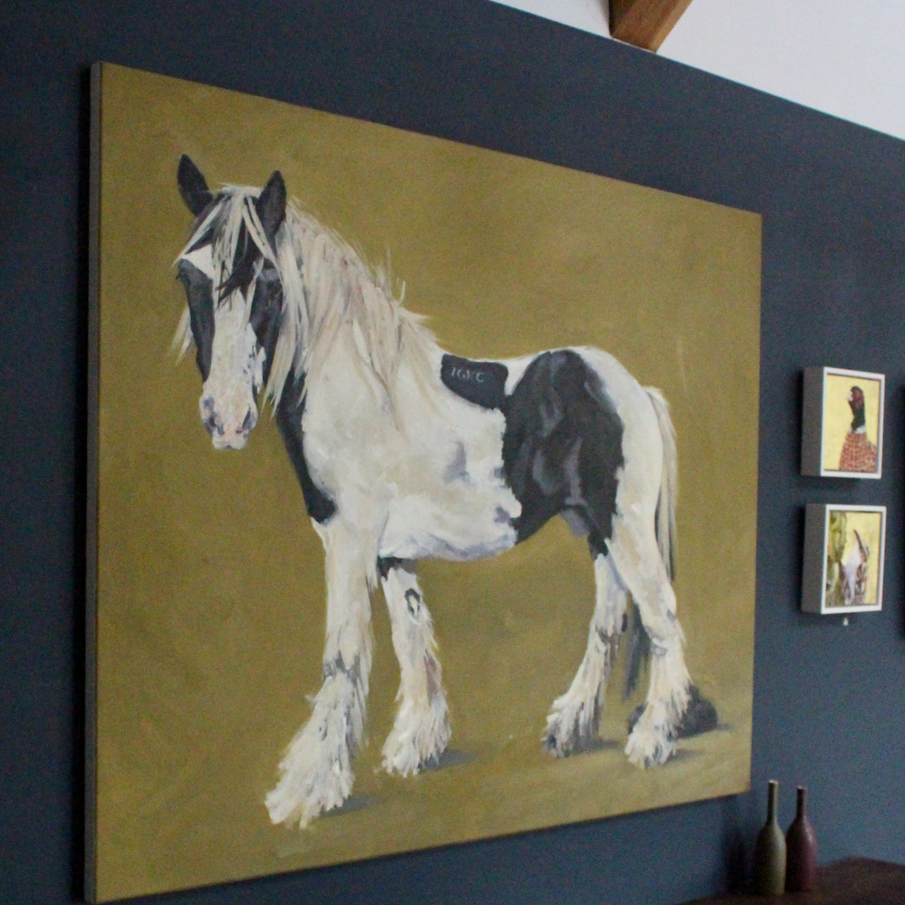 Jill Hudson painting of a large black and white horse on a mustard coloured background 