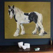 a Jill Hudson painting of a large black and white horse on a mustard coloured background.