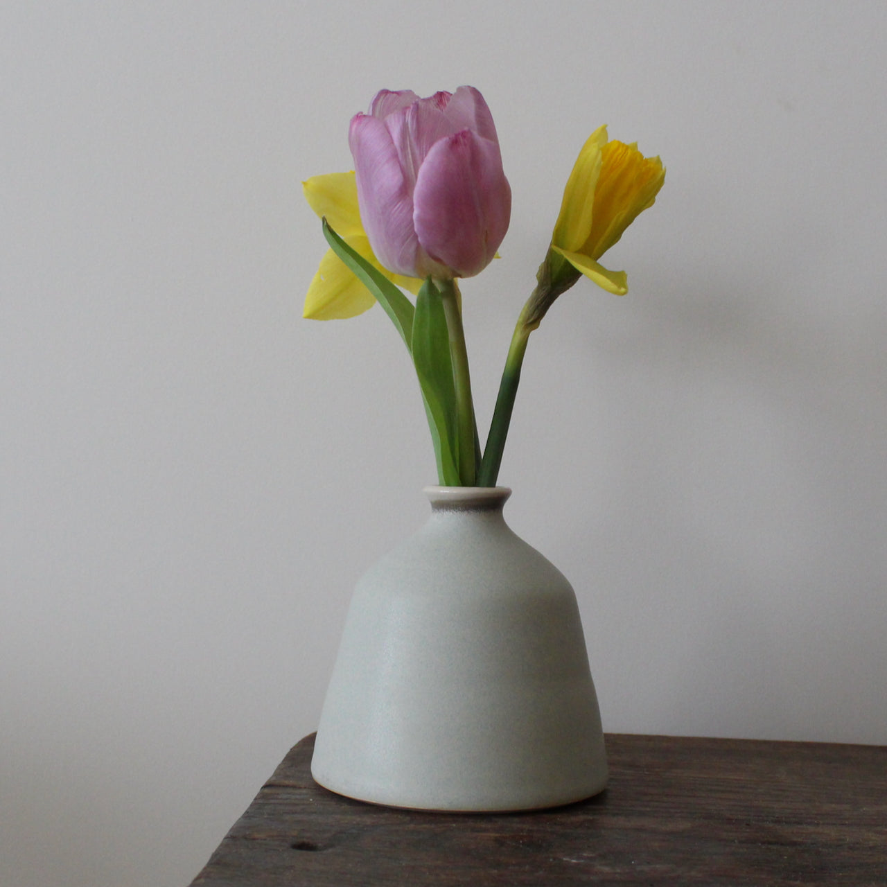 EOT ceramics pale grey bud vase with a pink tulip and two daffodils in it