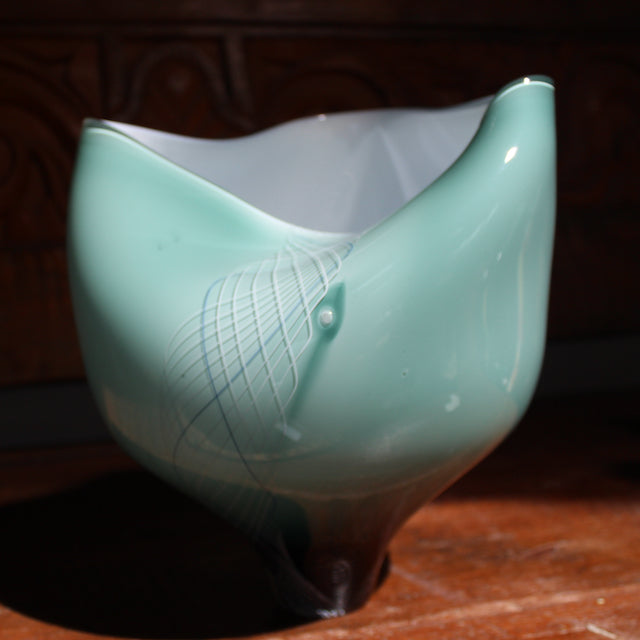 Glass buckled vessel in green and white by Benjamin Lintell