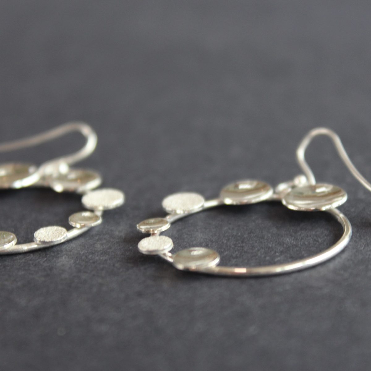 Round silver hoop earrings with small silver circles attached by Beverly Bartlett