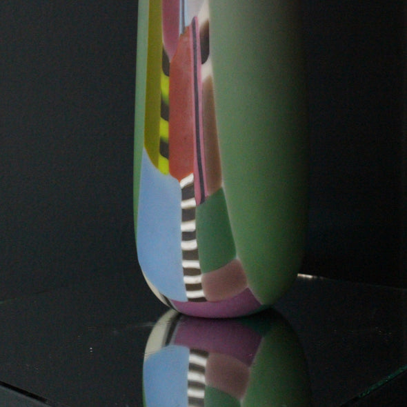 close up detail of a extra tall Ruth Shelley glass vase in shades of pink with central stripe d section in blues, red and greens 