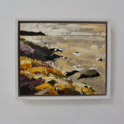 framed on a wall Cornwall artist Jill Hudson painting of Rame Head with yellow flowers and a sandy beach.