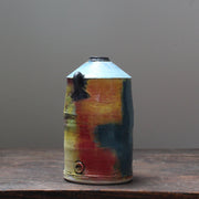 a ceramic vase with a tapered top and small lug handles by John Pollex, it is multi coloured with a blue top.
