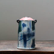 A ceramic vase with a tapered pink top and small lug handles by John Pollex, leading British ceramicist, i
