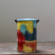 multi coloured ceramic vase with a tapered top and small lug handles by John Pollex, British potter.