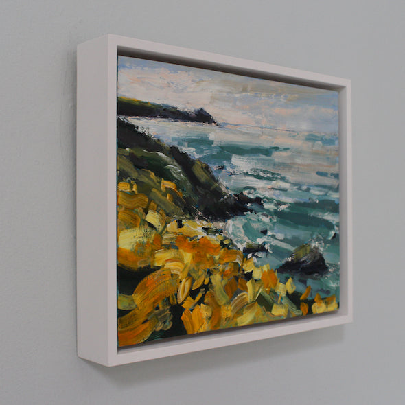 framed painting of a coastline with yellow flowers and a stormy sea, called Wild Yellows by  artist Jill Hudson 