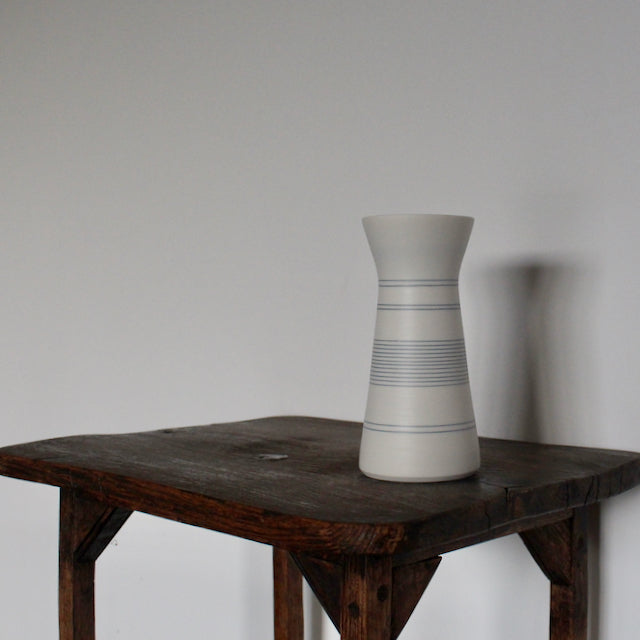 a white porcelain vase with blue ring design by Uk potter Kathryn Sherriff of By the Line Pottery.
