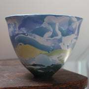 A tall porcelain bowl made of blue and yellow coloured clay in the Nerikomi style by ceramicist Judy McKenzie.