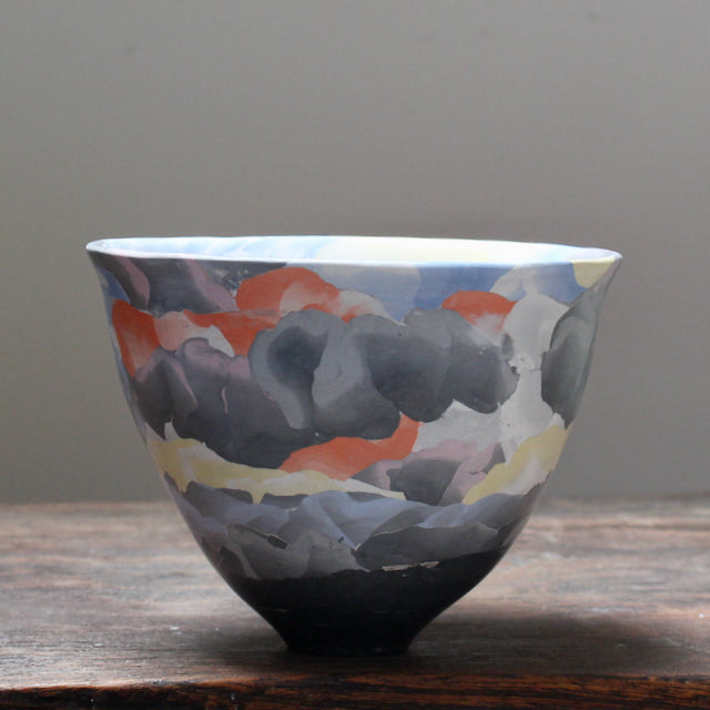 A porcelain Nerikomi style bowl in dark purple, orange and yellow by acclaimed ceramic artist Judy Mckenzie